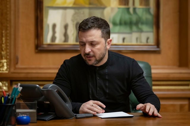 Volodimir Zelenszkij ukrán elnök telefonon beszél, komoly arckifejezéssel.
