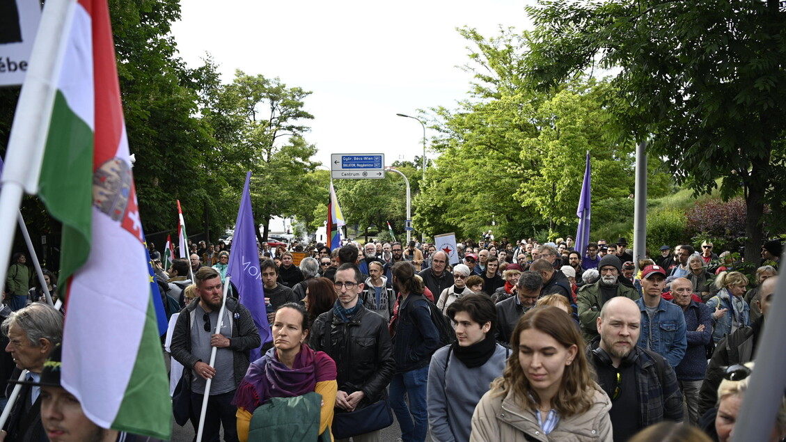Tüntetés résztvevői magyar és más nemzeti zászlók alatt vonulnak.