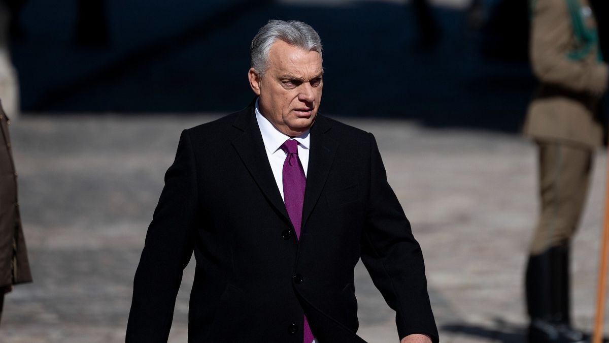 Orbán Viktor miniszterelnök komoly arckifejezéssel sétál.