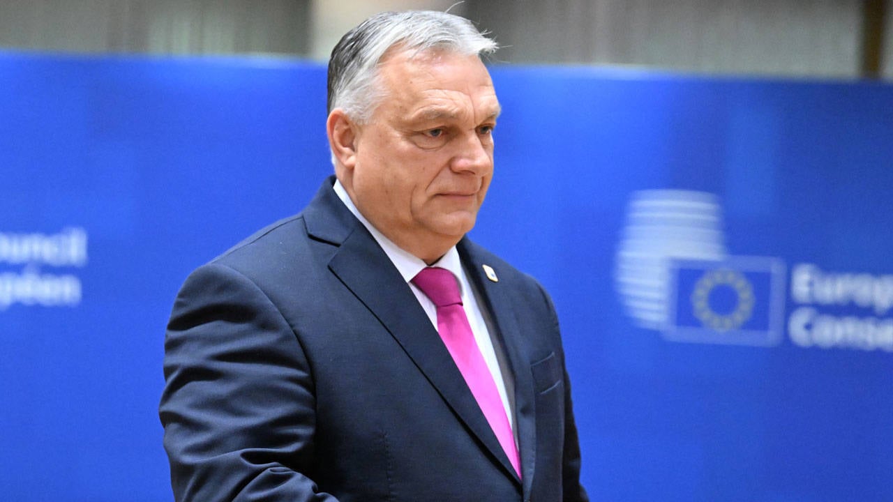 Orbán Viktor miniszterelnök komoly arckifejezéssel egy kék háttér előtt.